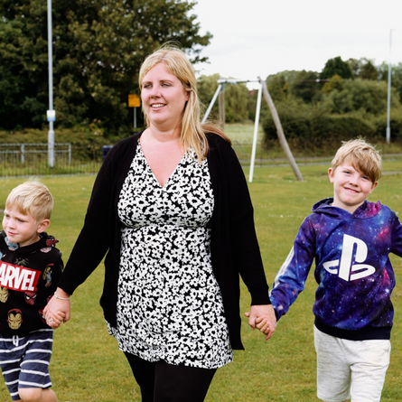 Emily holding hand with her children