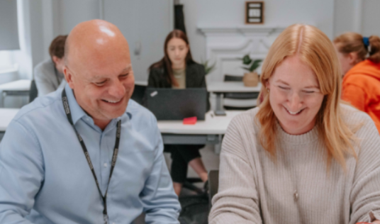 Two employees smiling at work